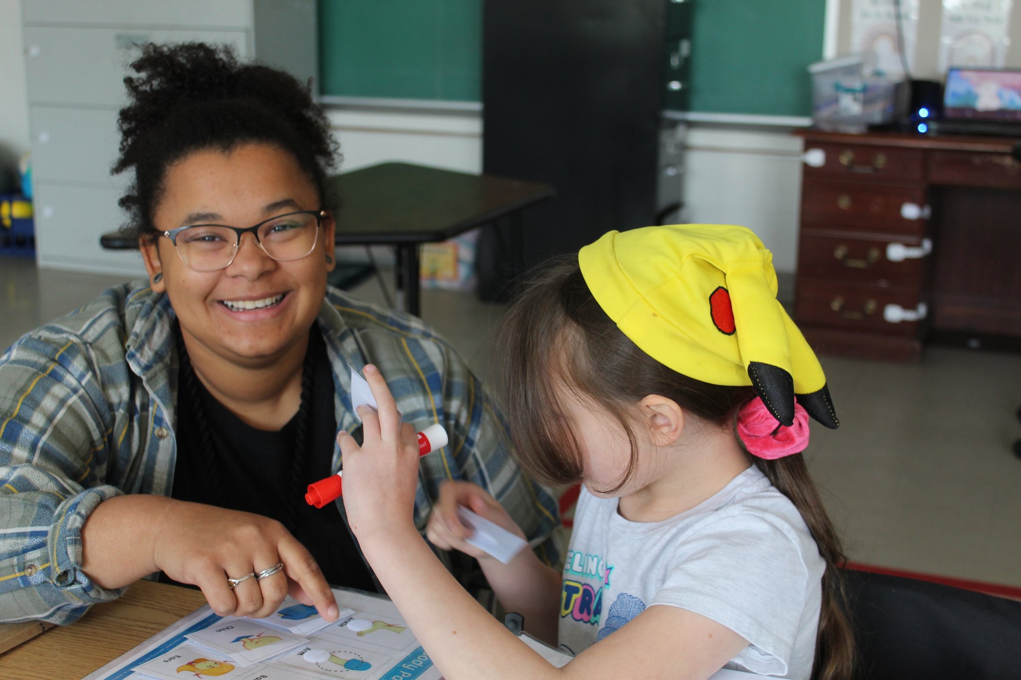 Teacher smiling while working with student (3)